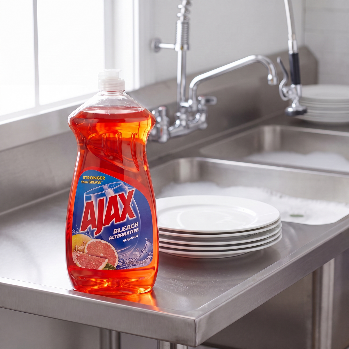 Ajax Ruby Red Grapefruit dish liquid 52 oz. bottle on the drainboard of a stainless steel commercial kitchen sink