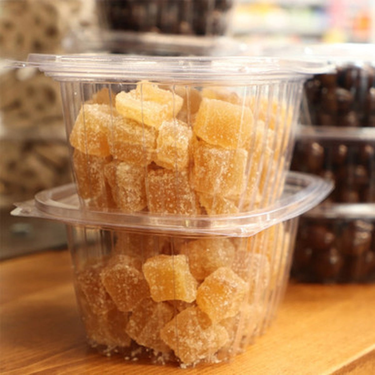 World Centric clear PLA lid fitted on stacked rectangular deli containers with candy