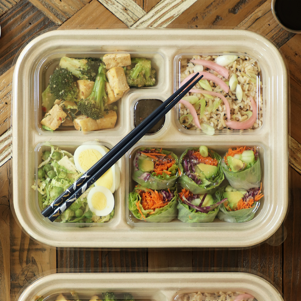 World Centric TRL-CS-BB clear PLA bento box lid covering a five-compartment prepared meal