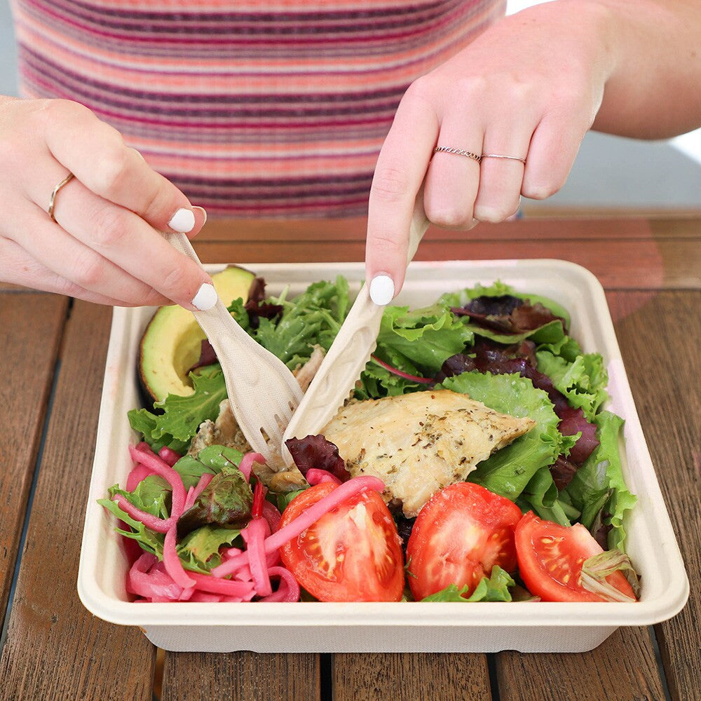 World Centric fiber knife used with a fresh salad in a fiber container