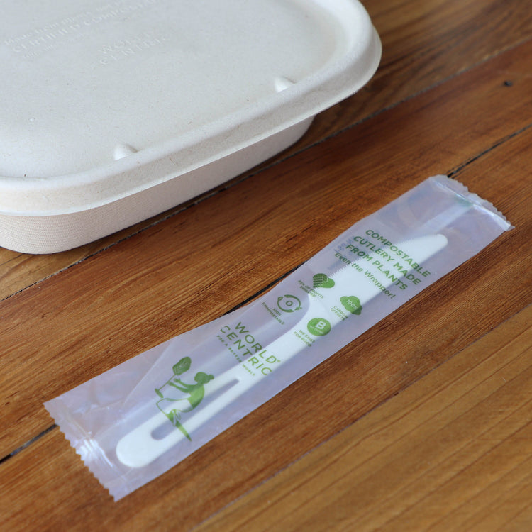 World Centric wrapped TPLA knife beside a fiber takeout container